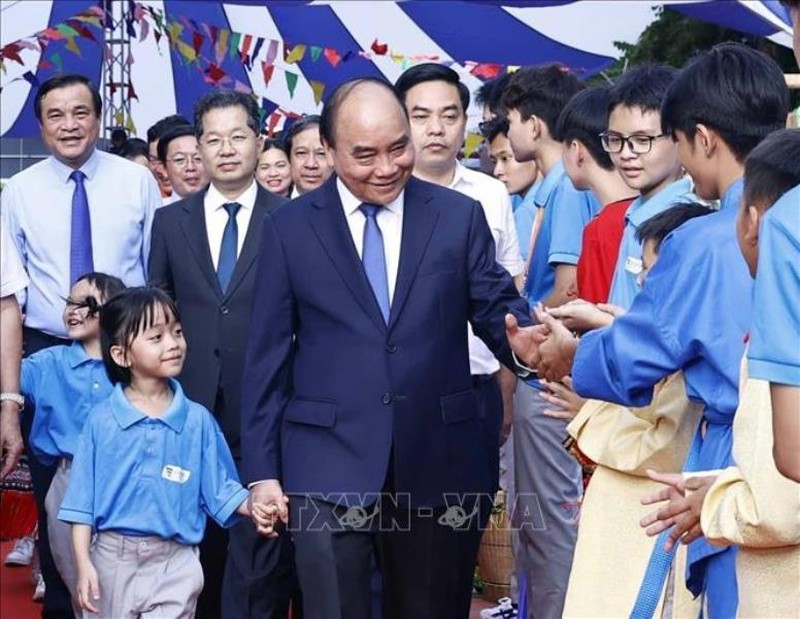 Chủ tịch nước Nguyễn Xuân Phúc cùng các em học sinh Hope School tại Ngày hội đến trường năm học đầu tiên. Ảnh: TTXVN