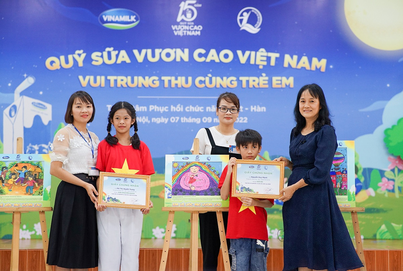 : Em Phí Thị Huyền Trang (giải khuyến khích) và Nguyễn Duy Mạnh (giải ba) nhận quà từ đại diện công ty Vinamilk