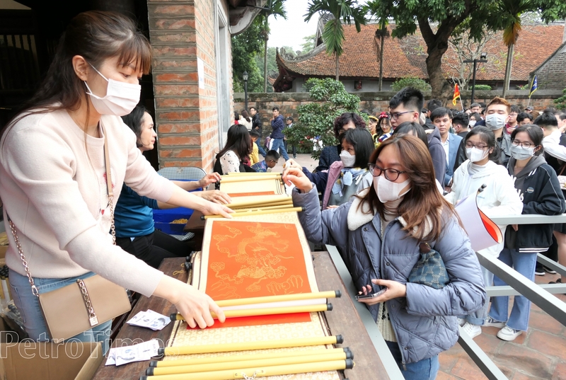 Người dân xếp hàng mua giấy đỏ trong khuôn viên Văn Miếu - Quốc Tử Giám.