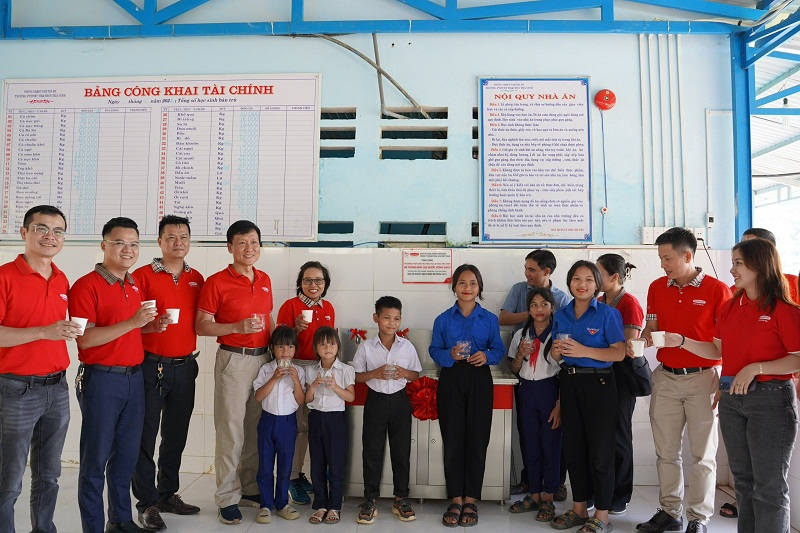 Đại diện Dai-ichi Life Việt Nam cùng nhà trường và các em học sinh thưởng thức nguồn nước uống sạch từ hệ thống máy vừa được trao tặng.