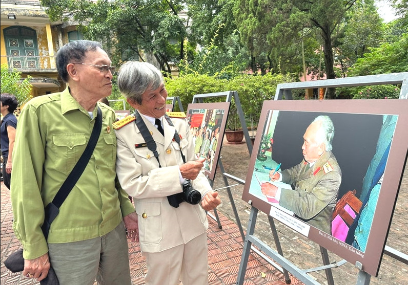 Đại tá, nghệ sĩ nhiếp ảnh Trần Hồng giới thiệu với người xem triển lãm một tác phẩm về Đại tướng Võ Nguyên Giáp.