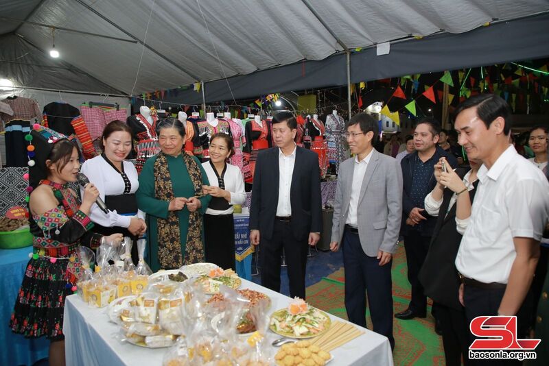 Đồng chí Tòng Thị Phóng và các đại biểu tham quan gian trưng bày ẩm thực xã Huy Tân.