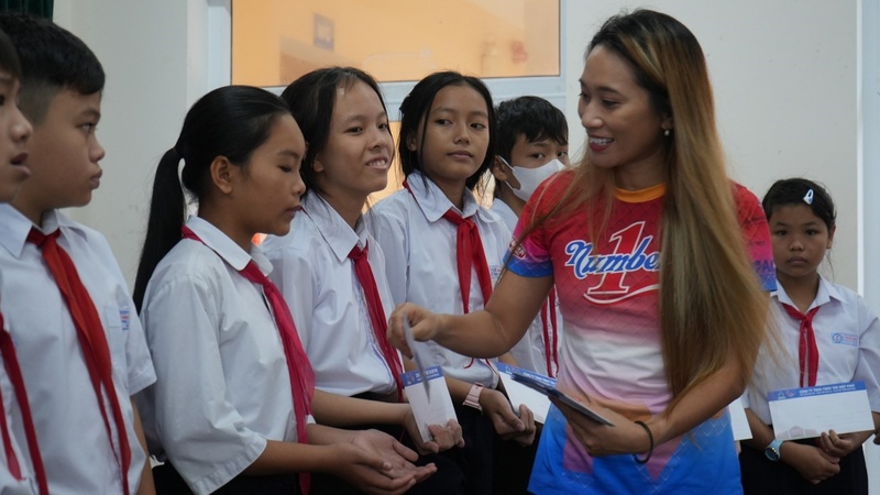 Chị Vũ Phương Thanh, đại sứ thương hiệu Nước tăng lực Number 1 trao học bổng và động viên các em học sinh vượt khó.