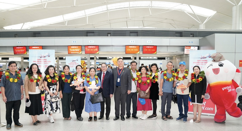 Phó Tổng lãnh sự Lào tại TP.Hồ Chí Minh, ông Souvannaseng Amphay cùng lãnh đạo Vietjet tặng hoa và chúc mừng những hành khách đầu tiên trên chuyến bay khai trương từ TP. Hồ Chí Minh đi Viêng Chăn, Lào