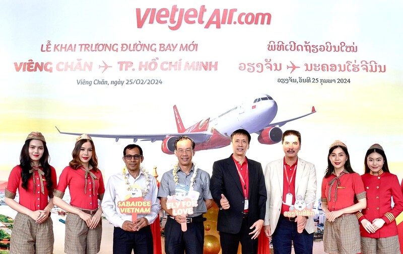 Phó Tổng giám đốc Vietjet Nguyễn Thanh Sơn tặng hoa và quà lưu niệm cho những hành khách đầu tiên