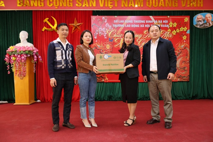 Từ trái qua phải nữ doanh nhân Lê Thị Dung và chồng trao quà cho lãnh đạo trường Lao động xã hội Thanh Xuân.