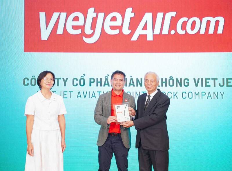 Ông Nguyễn An Di - Giám đốc Nhân sự Vietjet (áo T - shirt đỏ, áo khoác ghi xám) nhận giải thưởng tôn vinh Top 50 doanh nghiệp phát triển bền vững từ ban tổ chức