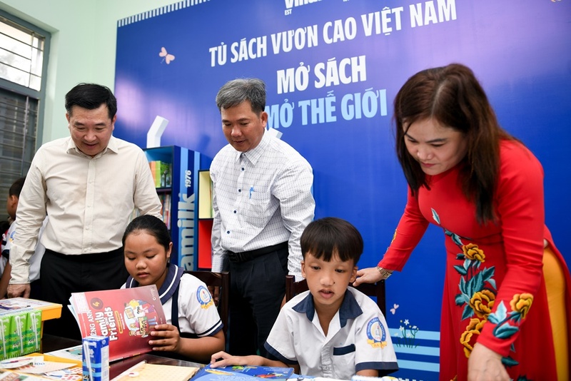 Các em học sinh khám phá tủ sách mới do Vinamilk trao tặng tại thư viện trường