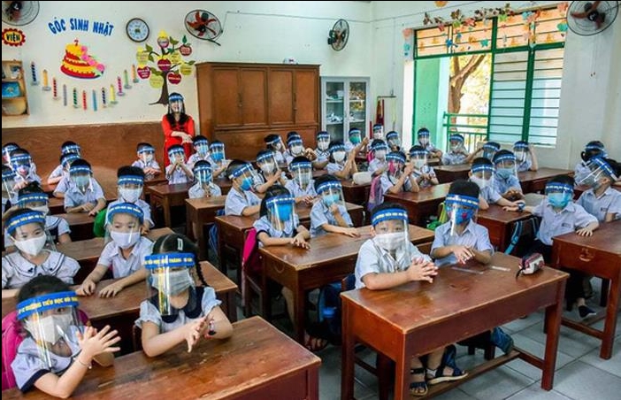 Học sinh một trường học đeo kính chắn khi tới tường.