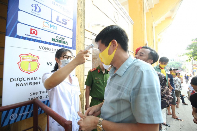 Mỗi khán giả đeo khẩu trang vàng do Hội CĐV Nam Định, được kiểm tra nhiệt độ, rửa tay sát khuẩn trước khi vào sân.