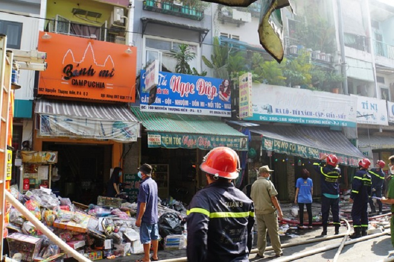 Lo sợ đám cháy sẽ lan sang, nhiều chủ cửa hộ kinh doanh bên cạnh di chuyển đồ ra ngoài đường (Ảnh: báo Tiền Phong)