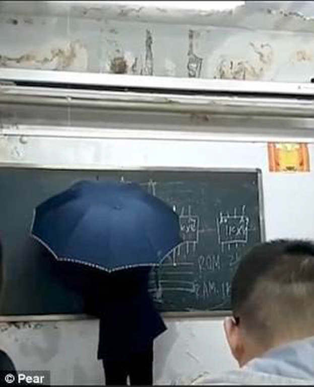 Hình ảnh thầy giáo vừa cầm ô che mưa vừa dạy học vì trường bị dột gây xúc động