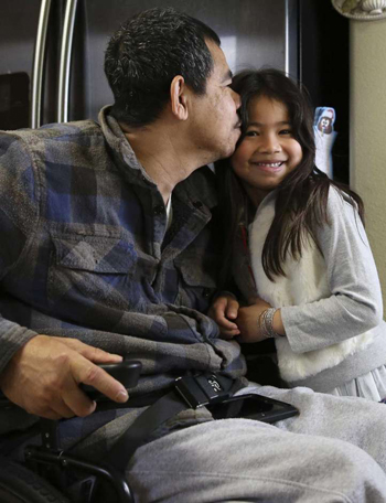 Khanh Hung Le, 47 tuổi, hôn lên trán con gái Tonya, 7 tuổi. Ảnh: Houston Chronicle. 