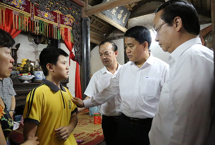 Chủ tịch UBND TP Hà Nội Nguyễn Đức Chung động viên con của nữ lao công.