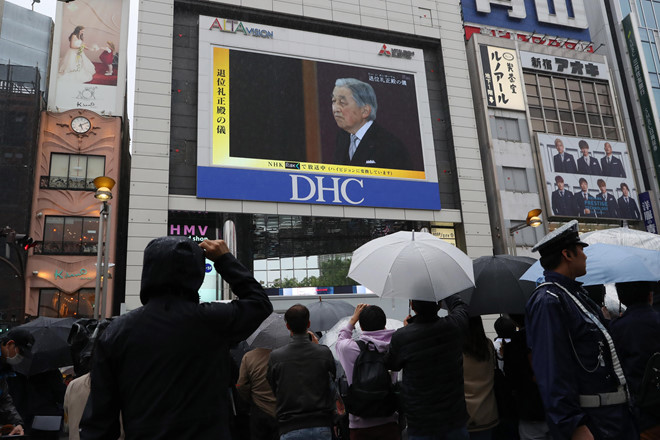 Người dân xem lễ thoái vị của Nhật hoàng được phát trực tiếp trên truyền hình ở các màn hình công cộng. Ảnh: Reuters.