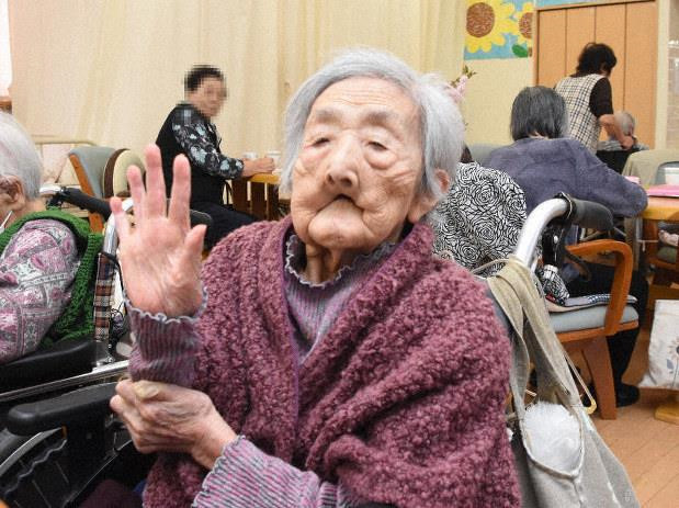Bà Miya Itoi giơ bàn tay, thể hiện mình đã sống qua 5 triều đại của Nhật Bản. Ảnh: Mainichi.