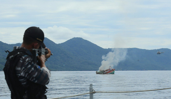 Binh sĩ Indonesia đánh chìm một tàu cá nước ngoài bị nước này bắt giữ với cáo buộc đánh cá trái phép. (Ảnh: AFP).