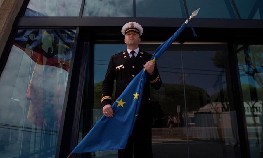 Một sĩ quan quân đội cầm cờ Liên minh châu Âu.
