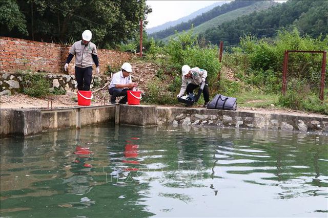 Cơ quan chức năng lấy mẫu nước tại khu vực Nhà máy nước sông Đà để kiểm tra (Ảnh: TTX).