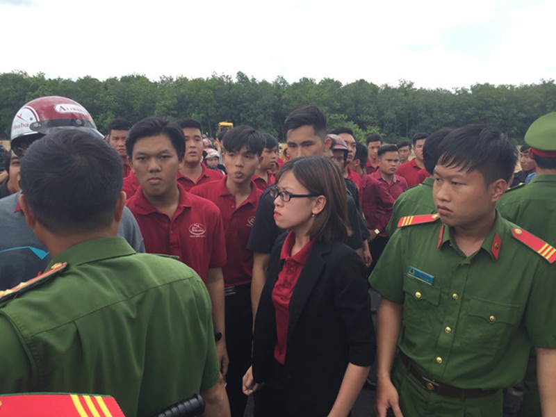 Huỳnh Tú Trinh (áo đen, đỏ) la lớn, kêu gọi nhân viên Alibaba đập phá phương tiện của đoàn cưỡng chế.