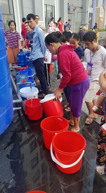 Hình ảnh cư dân chung cư Hateco Xuân Phương mang xô chậu xếp hàng xin nước.