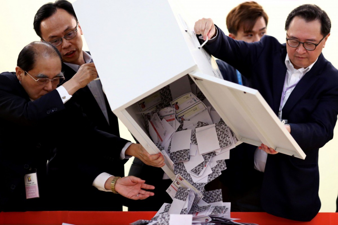 Các quan chức mở một thùng phiếu tại một khu vực bỏ phiếu ở Kowloon Tong, Hong Kong hôm 24/11.