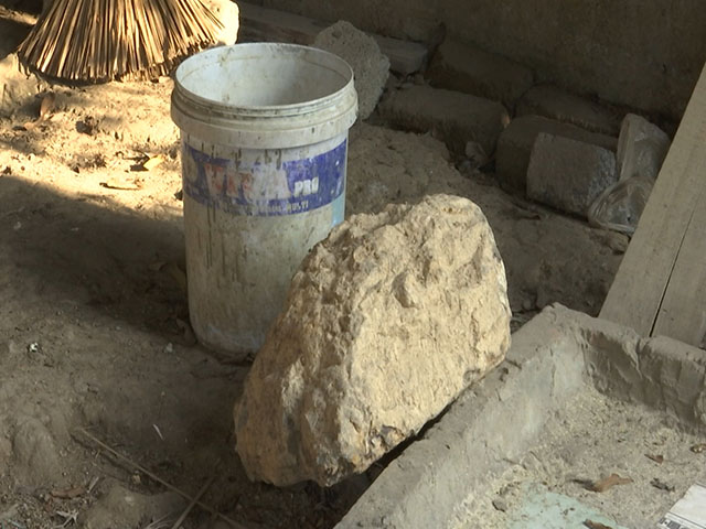 Tảng đá rơi từ khu vực thi công dự án xuống chuồng chó nhà dân. (Ảnh: Dân Việt).
