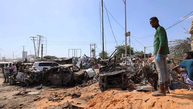 Một người đàn ông Somalia đứng tại hiện trường vụ nổ bom xe tại một trạm kiểm soát ở Mogadishu, Somalia hôm 28/12.