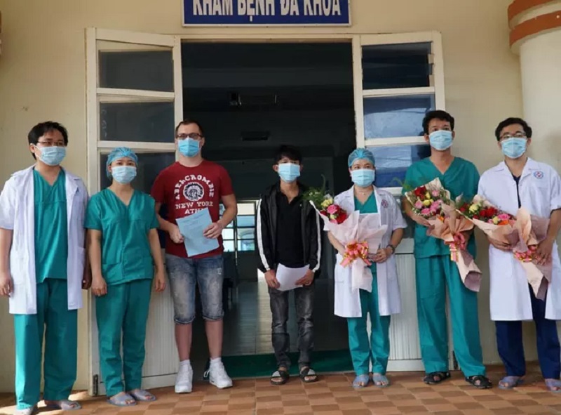 Các y bác sĩ Trung tâm Y tế huyện Bình Sơn trao chứng nhận điều trị khỏi bệnh cho 2 bệnh nhân 370 (áo đỏ) và 419 (áo đen). Ảnh: T.Trực