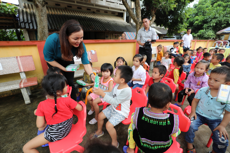 Các đại biểu trao tặng sữa tận tay cho các em học sinh tham dự chương trình.