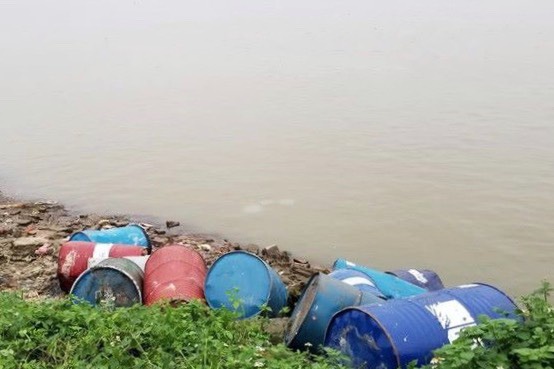 Những thùng phuy chứa chất thải công nghiệp được Hùng đổ trộm ra bờ sông Hồng. (Ảnh: V.Q).