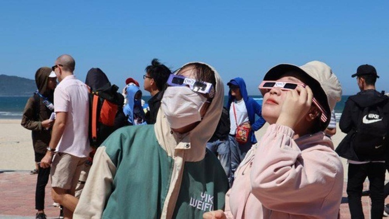 Người dân Đà Nẵng tập trung ngoài bờ biển với các loại kính chuyên dụng để quan sát Nhật thực. (Ảnh: Tuổi trẻ).