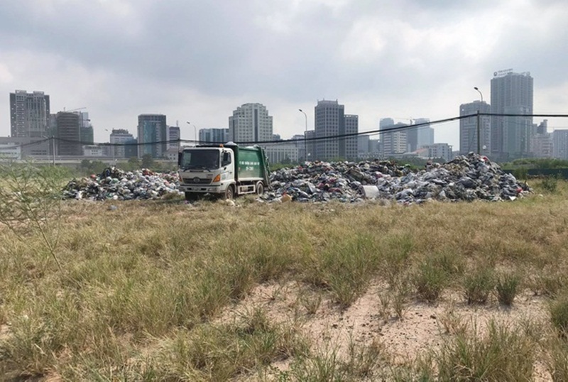 Xe tập kết rác tạm tại bãi đất trước Bến xe Mỹ Đình. (Ảnh: Dân Trí).
