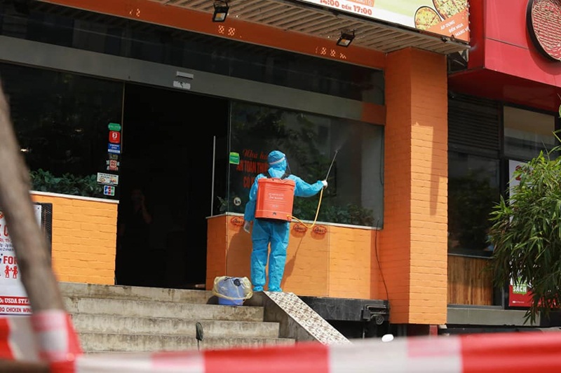 Lực lượng chức năng phong tỏa và phun khử khuẩn ở quán Pizza 106 Trần Thái Tông. (Ảnh: CTV).