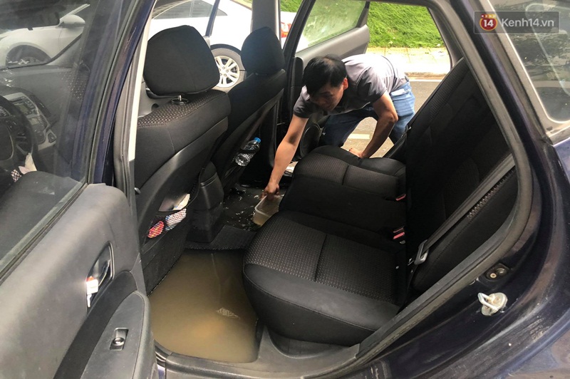 Nhiều chủ xe phải tát nước trong khoang để giải cứu ô tô. (Ảnh: Kênh 14.vn).