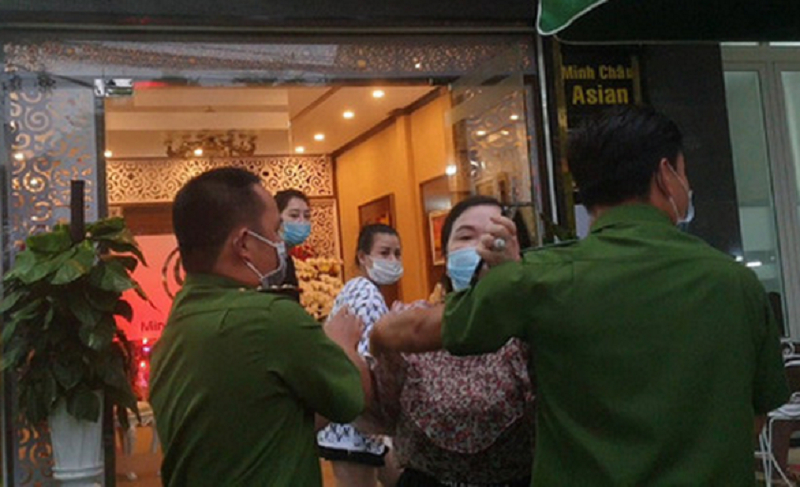 Bà Nguyễn Huân T. dù được 2 công an giữ lại vẫn chửi tục và có hành vi hành hung phóng viên. (Ảnh: L.Đ/ Tuổi Trẻ TP HCM).