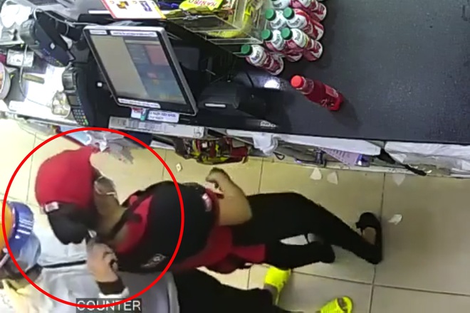 Nữ nhân viên cửa hàng tiện lợi bị kẻ cướp kề dao vào cổ khống chế cướp tiền.