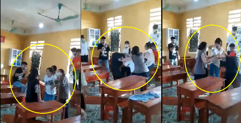 Nữ sinh lớp 9 (áo đen) bị 3 nữ sinh lao vào đánh đập hội đồng ngay trong lớp học ở Phú Thọ. Các bạn khác đứng bỏ điện thoại quay clip mà không vào can ngăn.