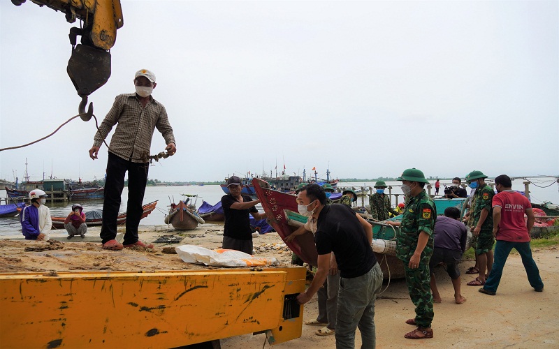 Cán bộ Đồn Biên phòng Cửa khẩu Cảng Cửa Việt hỗ trợ ngư dân di chuyển thuyền đến nơi an toàn. (Ảnh: Báo Quảng Trị).