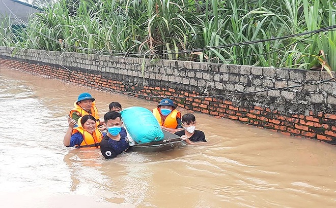Lực lượng cứu hộ cứu nạn vận chuyển lúa cho bà con ở vùng rốn lũ Quỳnh Lưu ra nơi an toàn (Ảnh: V.H).