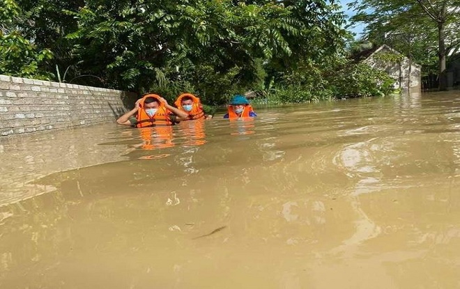 Lượng chức năng huyện Quỳnh Lưu bơi trong lũ để giúp dân.