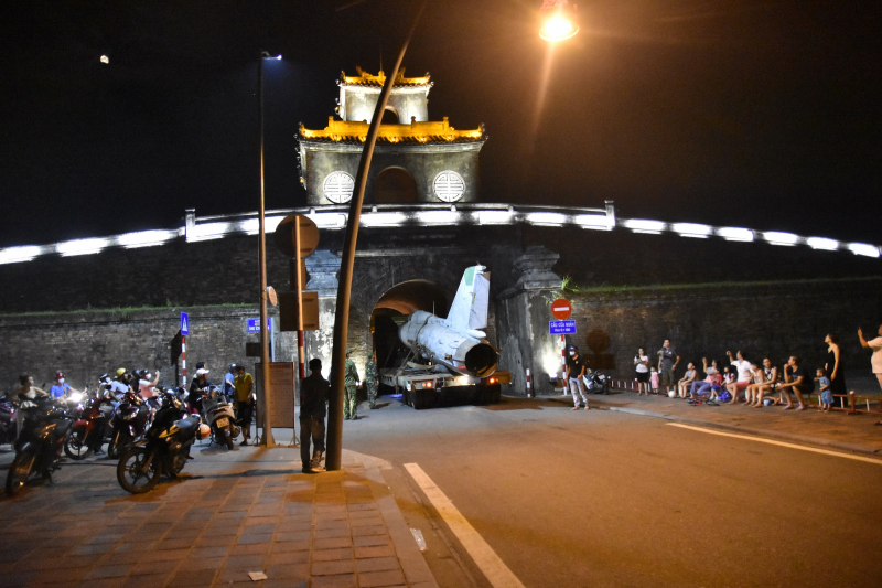 Máy bay được xe vận tải chở qua cổng thành.