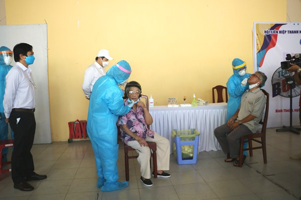 Người dân được các nhân viên y tế lấy mẫu dịch hầu họng.