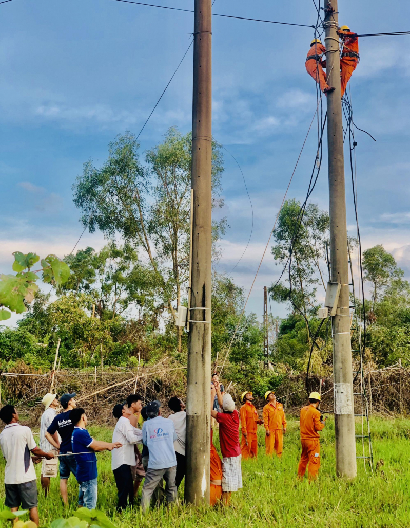 Người dân làng Phụ Ổ, Hương Trà giúp Điện lực phát quang cây đổ ngã và xử lý đường dây.