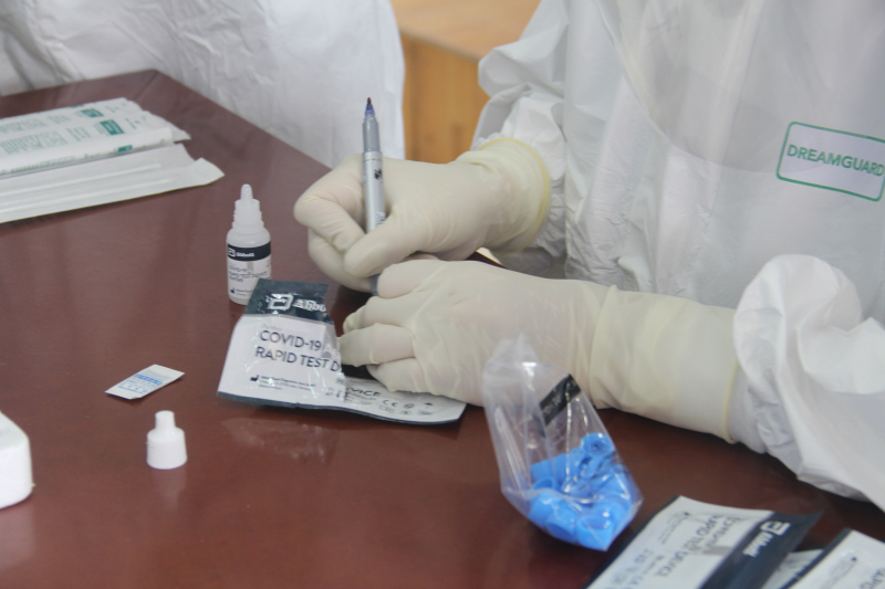 Nhân viên y tế tiến hành các công đoạn test nhanh kháng nguyên SARS-CoV-2.