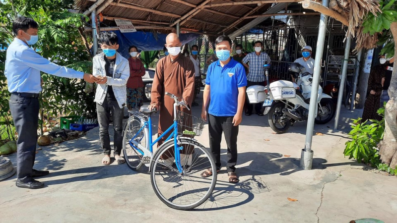 Thuận được bà con Quảng Nam trao xe đạp về quê.