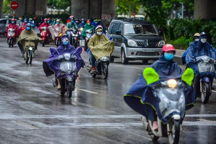 Giá lạnh kèm theo mưa, nhiều người dân mặc thêm áo khoác, áo mưa tham gia giao thông trong sáng thứ 2. Ảnh: NLĐ.