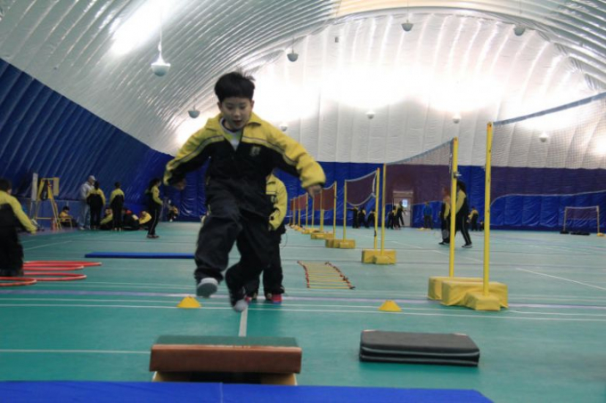 Học sinh tập thể dục dưới một mái vòm bơm hơi tại trường tư thục Huijia Bắc Kinh.
