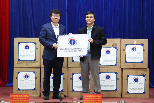 Thứ trưởng Bộ Y tế Trương Quốc Cường tặng khẩu trang y tế cho các đơn vị. Ảnh: Vietnam+.