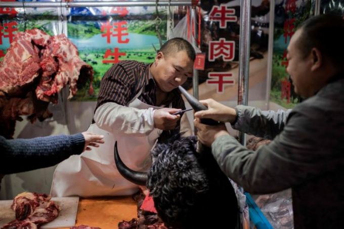 Một người bán thịt tại một khu chợ ở Bắc Kinh hôm 15/1.